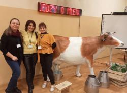 trzy nauczycielki stoją na tle eksponatu krowy